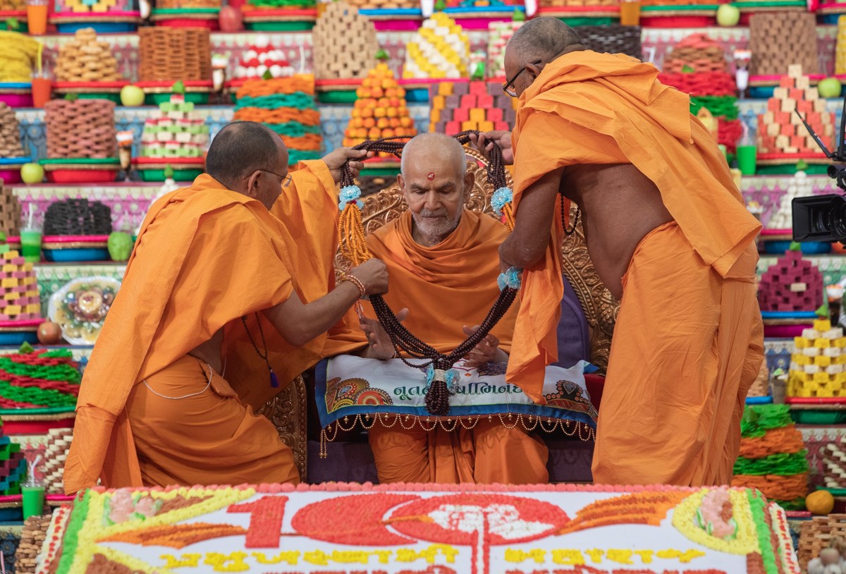 Sadhus honor Swamishri with a garland