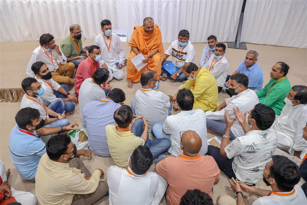 Attendees engaged in group discussion led by swamis