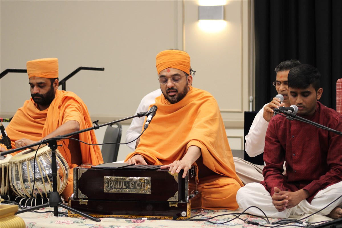 Swamis and youth begin the launch assembly with bhajans