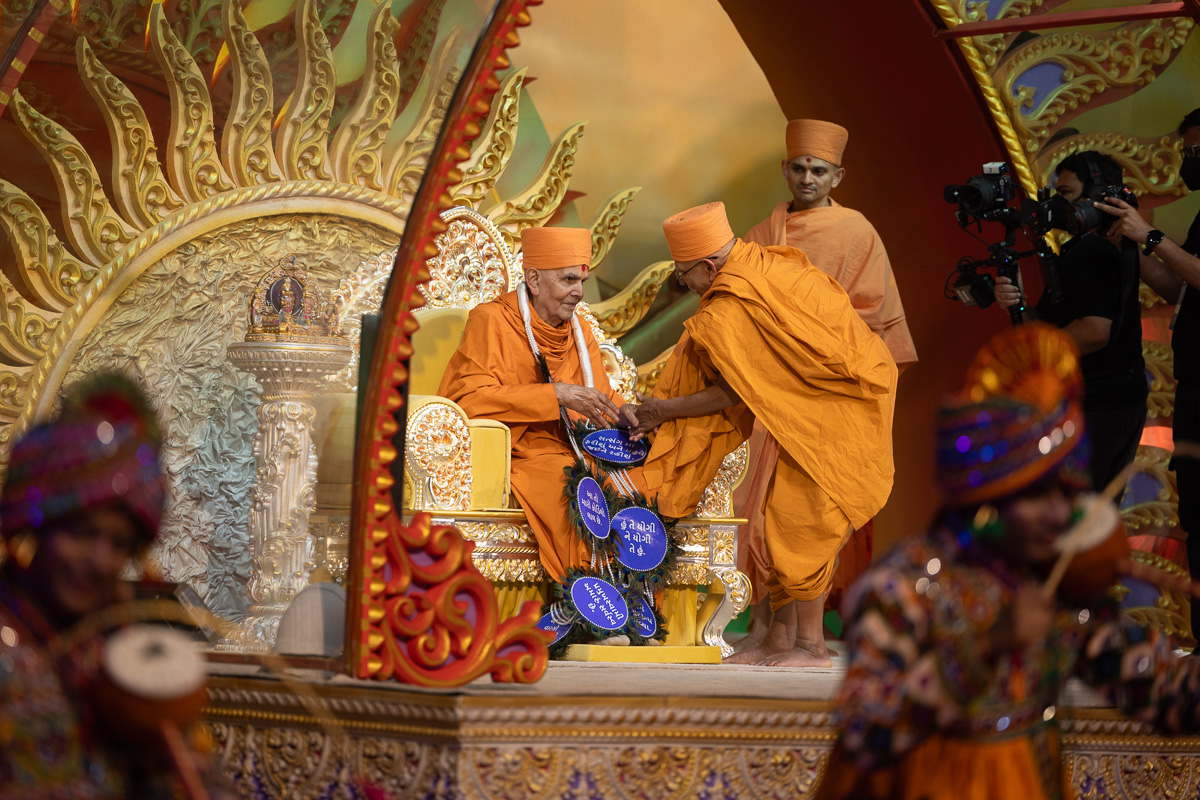 Pujya Tyagvallabh Swami honors Swamishri with a garland